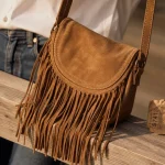 Sac a main à franges en daim camel, porté en bandoulière
