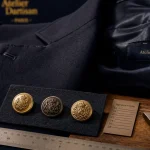 Boutons dorés pour blazer, mesure et pose en atelier de mercerie