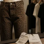 Jeans leopard femme en coupe droite, étiquette et prix barré sur comptoir