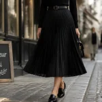 Jupe plisse midi noire fluide, reflets et plis visibles