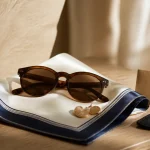 Accessoire luxe femme en soie, charms et finitions sur table en bois