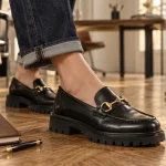 Mocassin femme tendance 2025 noir et doré en cuir, vue au sol